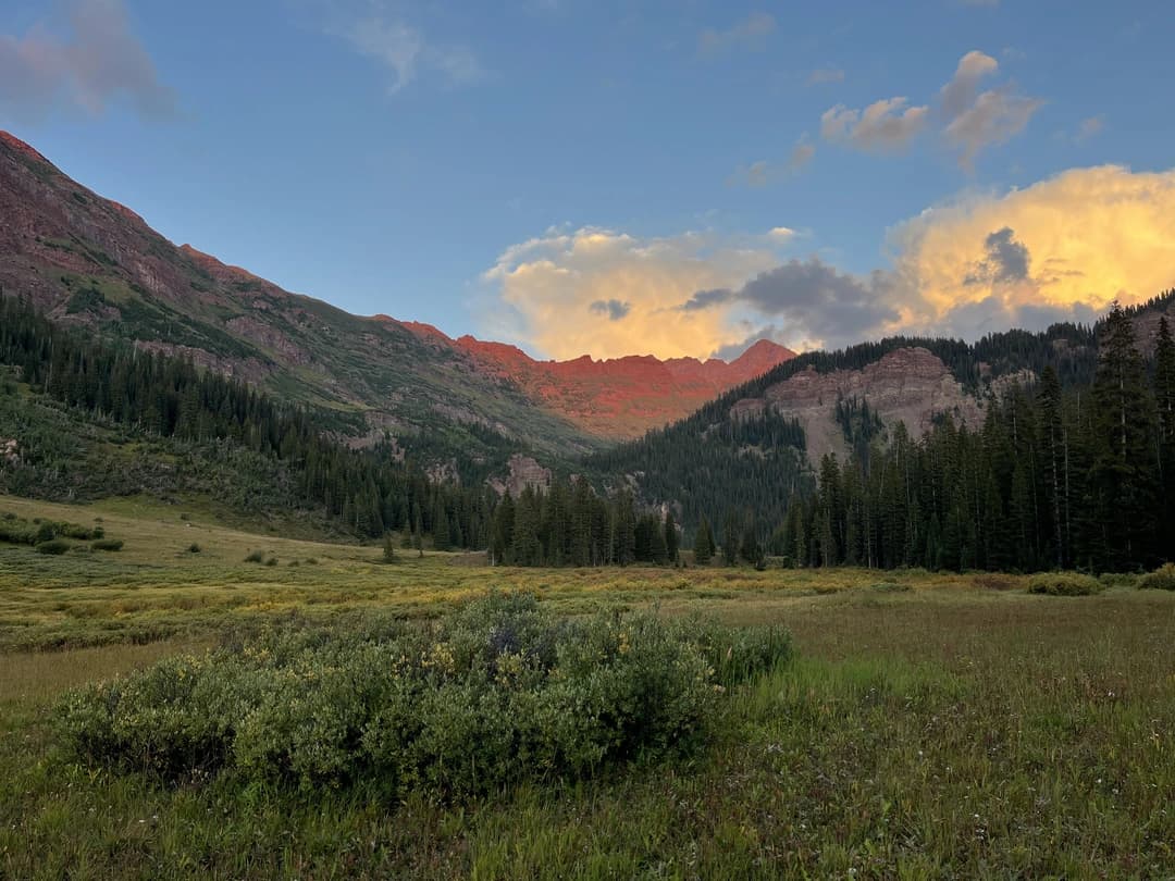 picture of a sunset over the mountains and a prairie